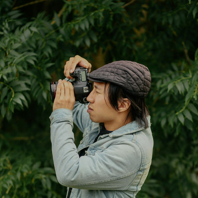 Person in a grey technical jacket holding a camera