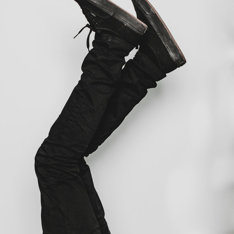 Pair of black leather shoes photographed against a grey background